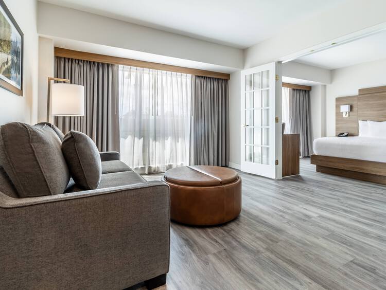 Bed next to desk with lamp and mirror on wall