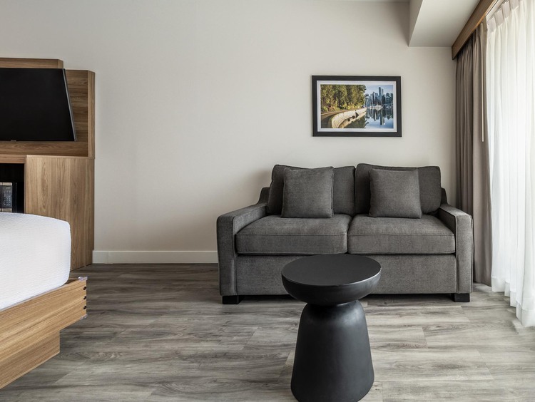 Two queen guest room with modern wood accents, white linens, and comfortable bedding.