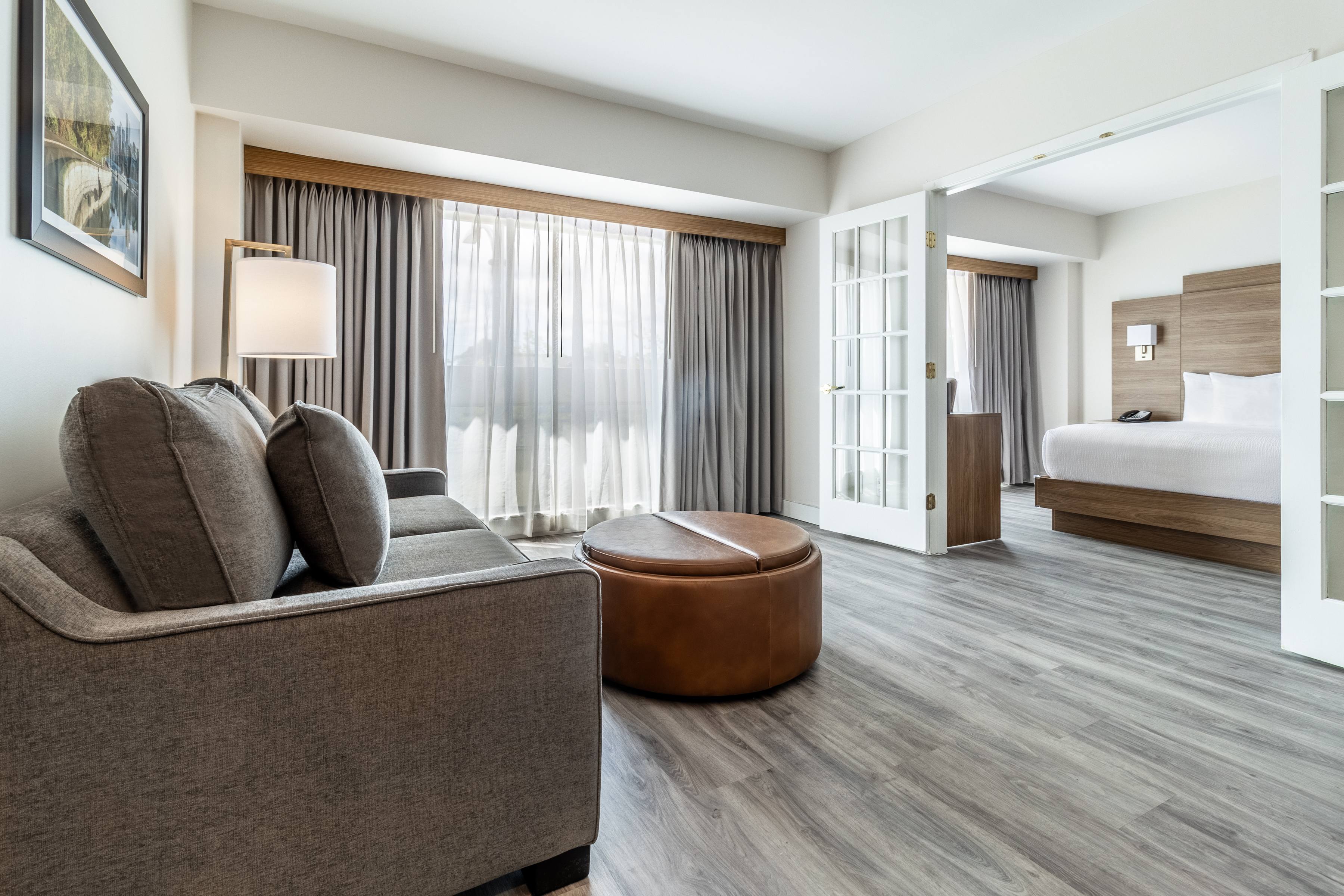 Bed next to desk with lamp and mirror on wall