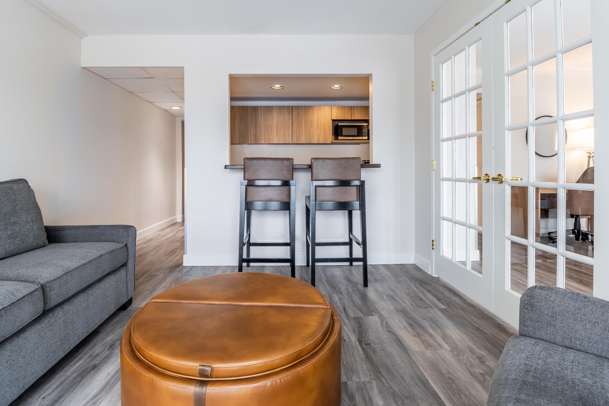 Sofa facing cofee table with kitchenette in background