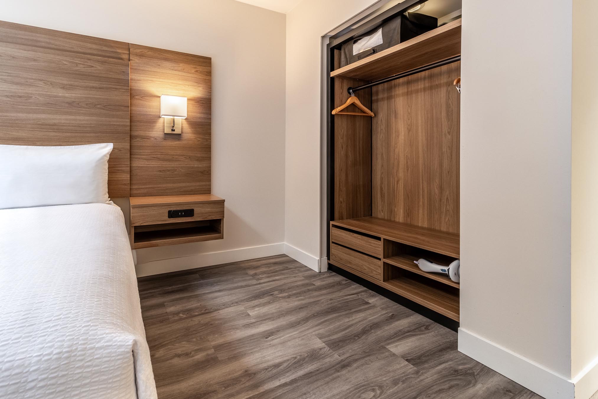 Queen bed and closet in hotel room