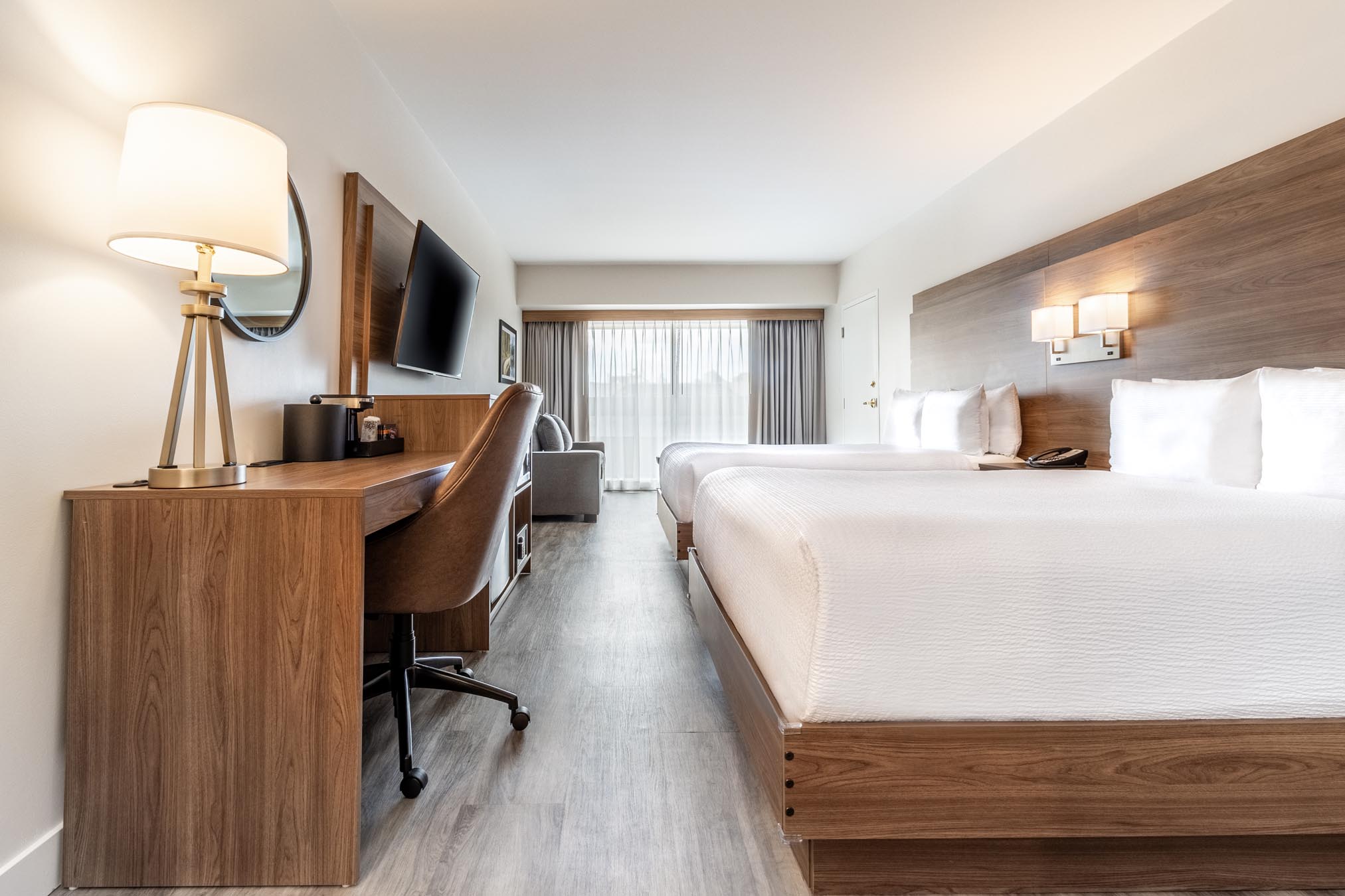 Bed facing desk with lamp at Atrium Hotel Vancouver