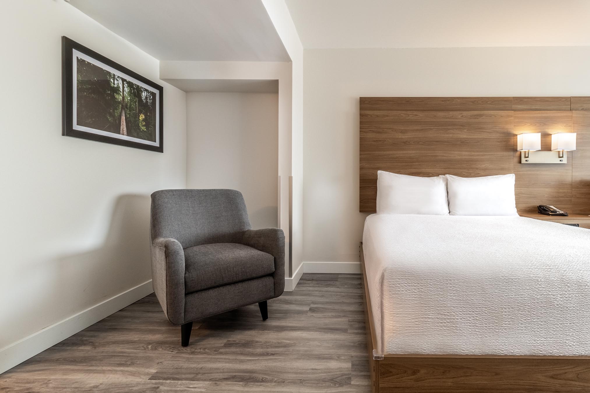 Chair and bed in hotel room accommodations in Vancouver.