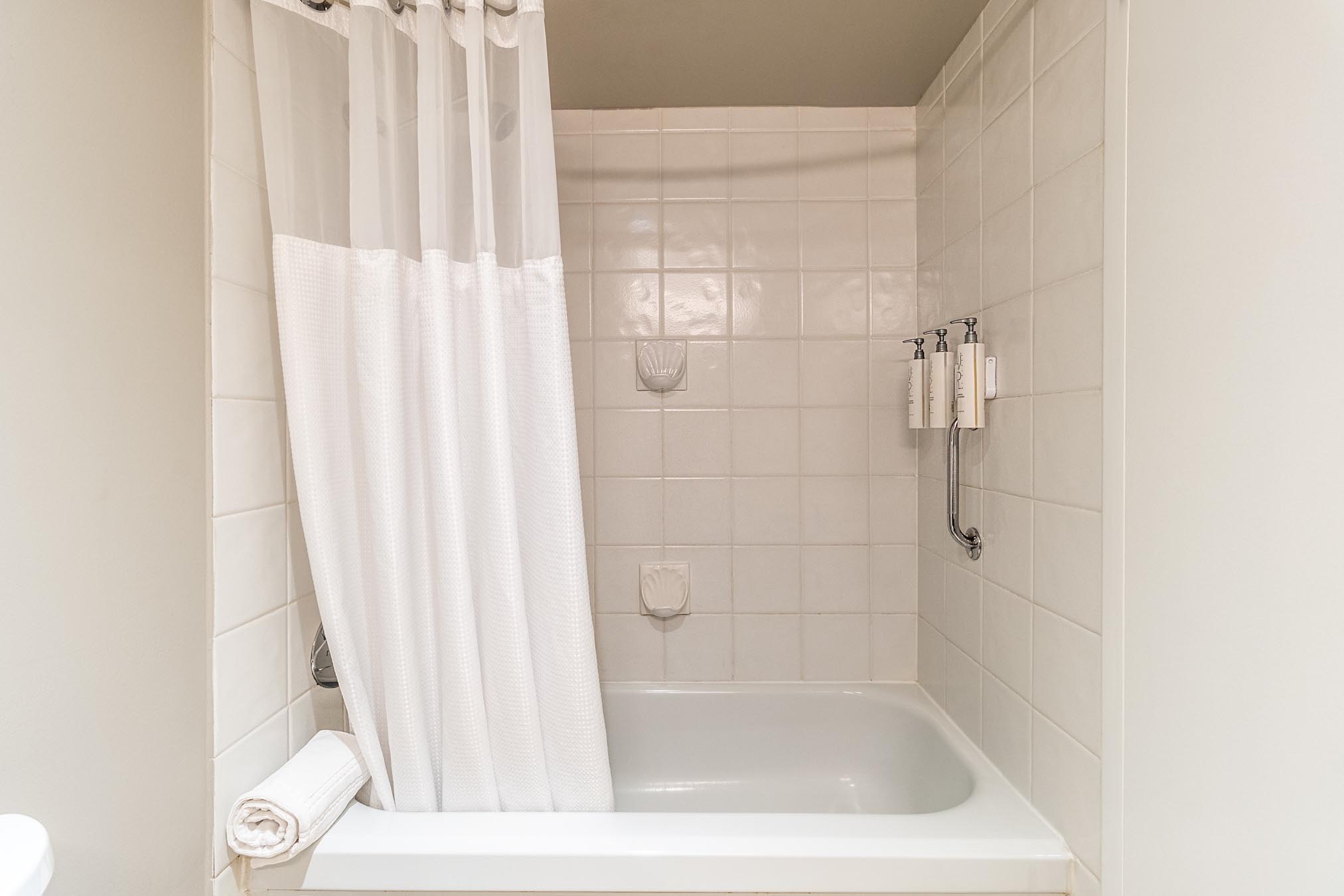 Shower/bath combination with white curtain